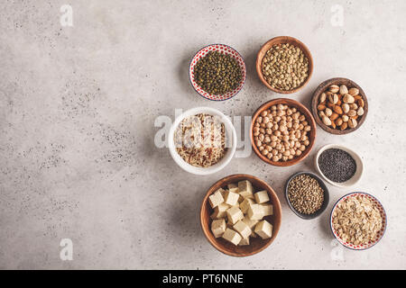 Vegan protein Quelle. Tofu, Bohnen, Kichererbsen, Nüsse und Samen auf einem weißen Hintergrund, Ansicht von oben, kopieren. Gesunde vegetarische Essen Konzept. Stockfoto