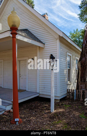 Alte weiße geschuppt Schulhaus mit Glockenturm auf der Pole und Straßenlaterne. Porträt. Wilmeth Schulhaus, Kastanie Square Historic Village, McKinney, Texas. Stockfoto