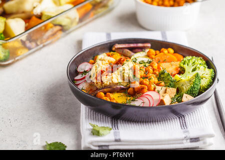 Vegan Buddha Schüssel mit gebackenem Gemüse, Kichererbsen, Hummus und Tofu auf weißem Hintergrund. Detox, sauber essen Konzept. Stockfoto