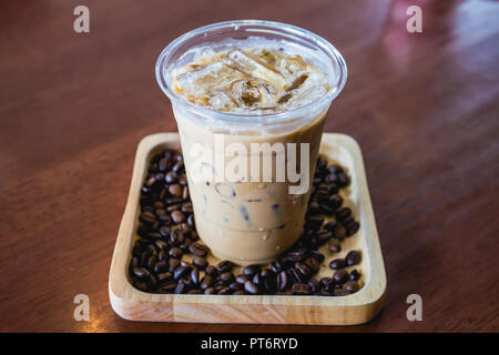 Kalter Kaffee trinken Frappe oder frappuccino in Holz Tablett mit Kaffee Bohne auf Holz Tisch Stockfoto