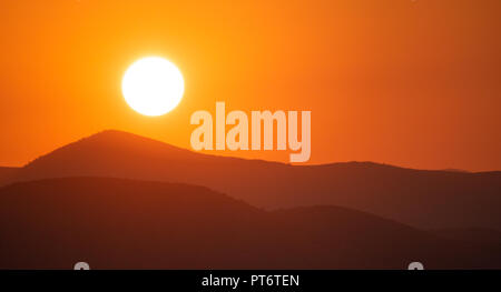 Sonnenuntergang, Sonnenaufgang über den Bergen Silhouette. Golden Sun auf bunten Himmel Hintergrund, Raum, Panoramaaussicht. Stockfoto