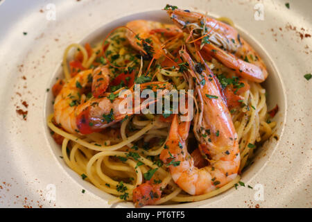 Gesunde Ernährung Konzept. Spaghetti mit Garnelen, Garnelen, gehackte Petersilie und Tomaten auf weiße Platte. Nähe zu sehen. Stockfoto