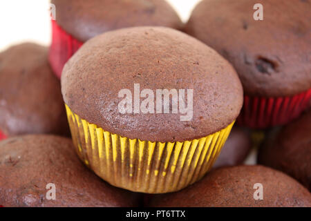 Eine Gruppe von Schokolade Muffins in Gelb und Rot Cups. Stockfoto