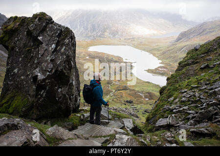 Ein älterer Mann Wanderer absteigend Küche Weg des Teufels in Cwm Idwal mit niedrigen Cloud auf Berge von Snowdonia National Park. Ogwen Gwyned Wales UK Stockfoto