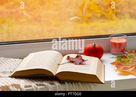 Herbst noch leben. Bücher, Blätter, Schale und Kerzenständer auf Fenster. Stockfoto