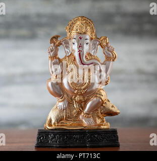 Eine kleine Plastik murti der hinduistischen Gottheit Ganesh / Ganesha, Schnüffeln ein reiskuchen, Reiten eine Ratte/Maus und halten eine Axt und Schlinge. Stockfoto