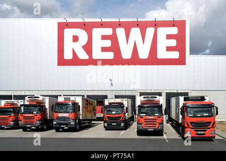 Nutzfahrzeuge bei REWE distribution center. REWE betreibt rund 3.300 Supermärkte in Deutschland. Stockfoto