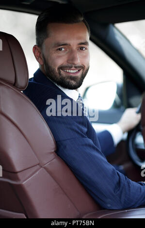 Unternehmer sitzen am Steuer eines Autos, und wenn man die Kamera Stockfoto