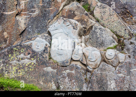 Gesichter am Fels als Teil der Stein & Mann Skulptur, Qaqortoq, Grönland Stockfoto