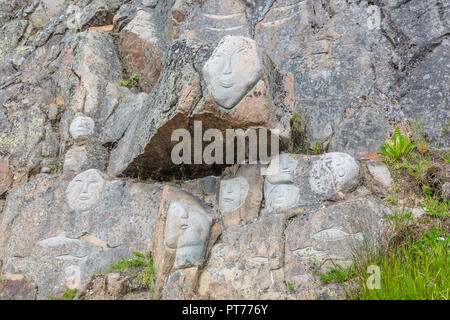 Gesichter am Fels als Teil der Stein & Mann Skulptur, Qaqortoq, Grönland Stockfoto