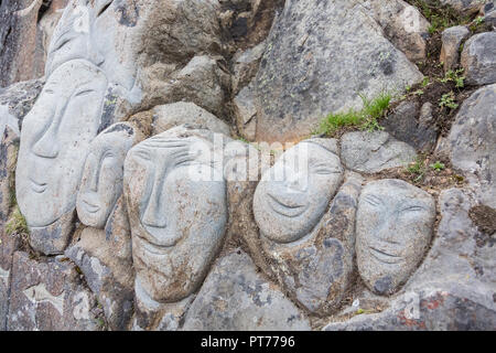 Gesichter am Fels als Teil der Stein & Mann Skulptur, Qaqortoq, Grönland Stockfoto