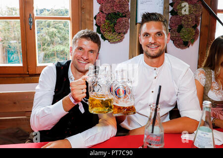 München, Bayern. 07 Okt, 2018. 07 Oktober 2018, Germany, München: Thomas Mueller und Sven Ureich vom FC Bayern München sitzen nebeneinander auf dem Oktoberfest auf der Theresienwiese. Spieler, Trainer und Manager des Fußball-Erstligisten FC Bayern Traditionell besuchen die KAEFER-Zelt zusammen einmal während des Oktoberfestes. Quelle: Bayern München-Paulaner/dpa - ACHTUNG: Die redaktionelle Nutzung nur in Verbindung mit der aktuellen Berichterstattung und nur, wenn die oben genannten ist in vollem/dpa/Alamy Leben Nachrichten referenziert Stockfoto