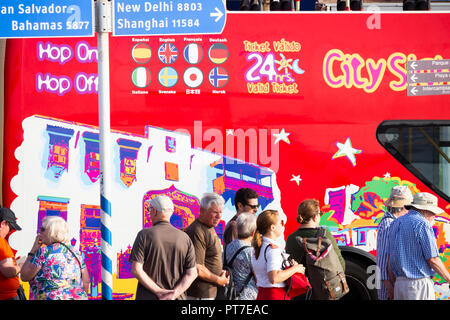 Las Palmas, Gran Canaria, Kanarische Inseln, Spanien. 7. Oktober 2018. Wetter: Kreuzfahrtschiff Passagiere Warteschlange board a City Sightseeing Bus in Las Palmas als drei große Kreuzfahrtschiffe mit rund 10.000 Passagiere, viele aus Großbritannien, Dock in Las Palmas an einem heißen Sonntag Morgen auf Gran Canaria,, mit Temperaturen um 30 Grad Celsius Prognose für den Rest des Tages. Stockfoto