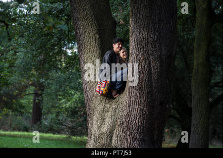 Kew Gardens, London. 7. Okt 2018. UK Wetter: 07.10.2018, London, UK Farben des Herbstes in Kew Gardens, London. Ein paar stehlen einige private Moment auf einem Baum Credit: Chandra Prasad/Alamy leben Nachrichten Stockfoto