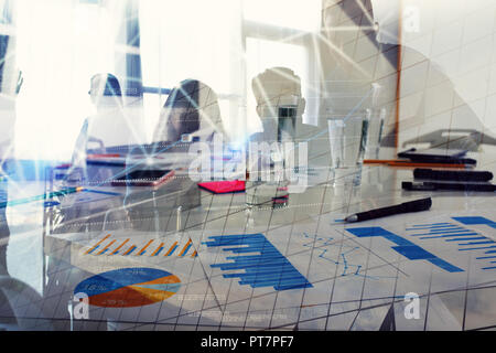 Silhouette der jungen Arbeitnehmer im Büro mit Statistik Arbeitsblätter. Konzept der Teamarbeit und Business. Double Exposure Stockfoto