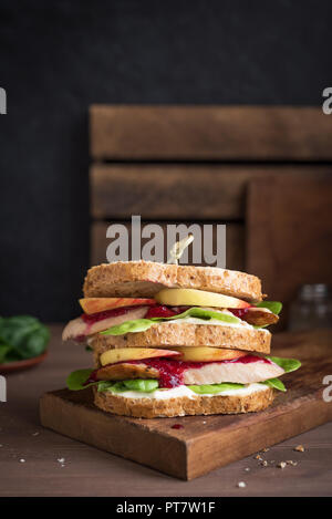 Truthahn oder Hähnchen übrig gebliebene Sandwich mit Füllung und Preiselbeersoße. Frisch von Thanksgiving oder Weihnachten Türkei Reste auf knusprigem wholemea gemacht Stockfoto