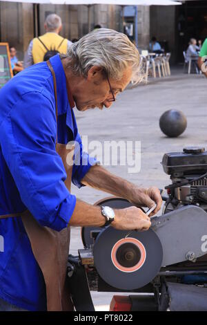 Mann Messerschärfer Schärfen der Messer auf einem schleifstein von hinten von einem Moped auf der Las Ramblas Barcelona Spanien Stockfoto