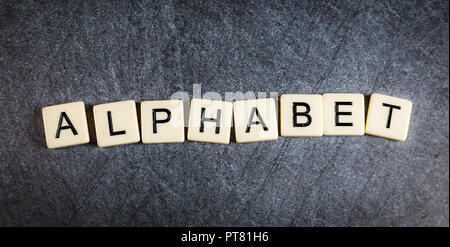 Schreiben Fliesen auf schwarzem Schiefer Hintergrund Rechtschreibung Alphabet Stockfoto