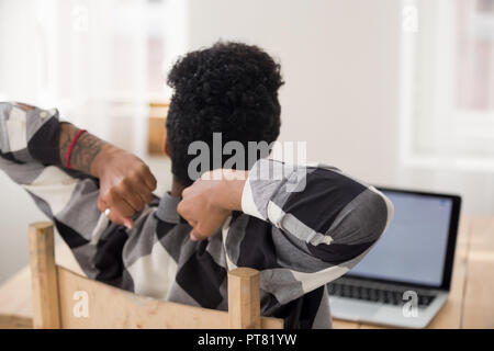 Afrikanische Frau an der Rezeption entspannen im Büro zu sitzen Stockfoto