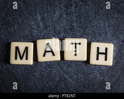 Schreiben Fliesen auf schwarzem Schiefer Hintergrund Rechtschreibung Mathe Stockfoto