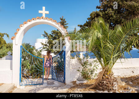 Eine junge Frau, die in der Tor der griechischen Kirche an einem sonnigen Sommertag. Serifos, Griechenland Stockfoto