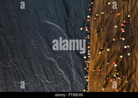 Blick von oben auf die Farbe Pfeffer auf hölzernen Schreibtisch und Schwarzen Tisch Hintergrund Stockfoto
