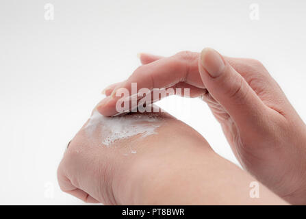 Frau Anwendung lotion Creme auf die Hände weiß isoliert Hintergrund Stockfoto