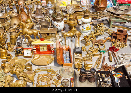 Lemberg, Ukraine - Juli 10, 2015: Verschiedene Dinge aus gelbem Metall zum Verkauf auf einem Flohmarkt. Dekorative Figuren, Münzen, Lampen und andere alte und Vi Stockfoto