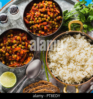 Vegan curry mit grünen Erbsen und Basmatireis auf einem blauen Tisch Tablett serviert, gesunde indische Speisen Stockfoto