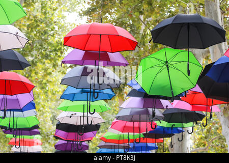 Eine strasse Installation von bunte Sonnenschirme, die in der Luft schweben. Stockfoto