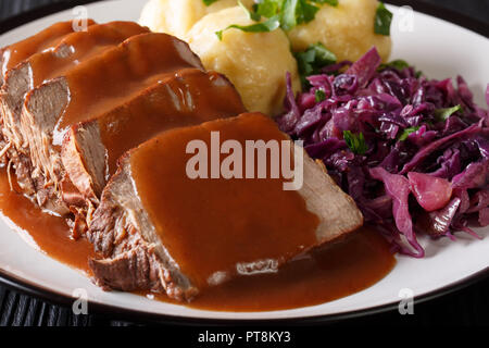 Deutsche braten Topf Sauerbraten mit Klößen und Rotkohl close-up auf einem Teller. Horizontale Stockfoto