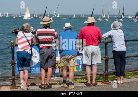 Ein Abschleppen von älteren oder älteren pensionierten Männer und Frauen beobachten die Yachten Racing auf der Parade in Cowes auf der Isle of Wight. Stockfoto