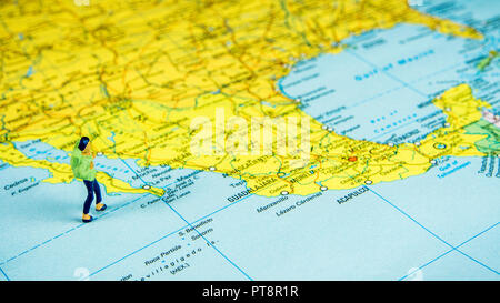 Nahaufnahme der Miniatur Figur der jungen Reisenden stehen auf große Karte Mexiko Stockfoto