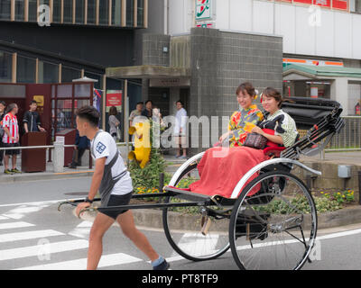 Tokio, Japan. September 11, 2018. Zwei Mädchen, die traditionellen Kimono eine Rikscha Fahrt in Asakusa. Stockfoto
