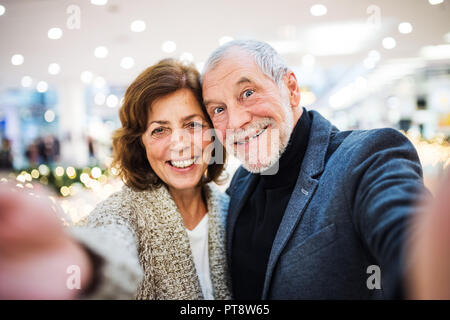 Senior Paar unter selfie im Einkaufszentrum zur Weihnachtszeit. Stockfoto