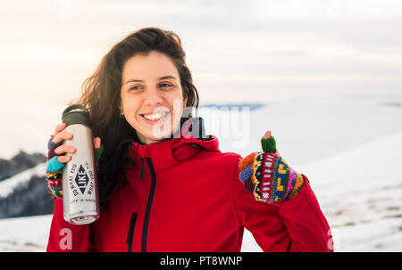 Happy girl Wanderer mit Thermoskanne auf verschneiten Berg Stockfoto