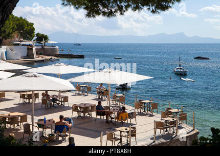 ALCUDIA, MALLORCA, SPANIEN - September 24rd, 2018: die Menschen genießen Sie sonnige Nachmittag auf der Terrasse des Restaurant auf Cala Poncet Beach in der Nähe von Port d'Alcudia. Stockfoto