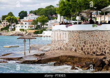 ALCUDIA, MALLORCA, SPANIEN - 26. September 2018: Leute genießen, sonnigen Nachmittag auf der Terrasse des Restaurant auf Cala Poncet Beach in der Nähe von Port d'Alcudia. Stockfoto