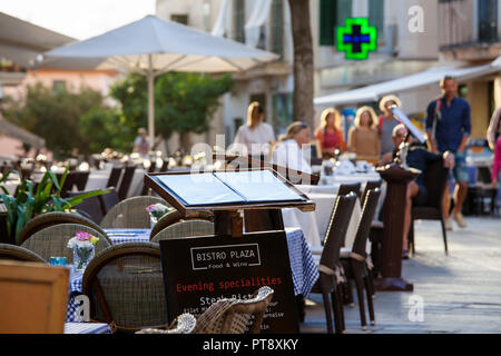 ALCUDIA, MALLORCA, SPANIEN - Oktober 2., 2018: Restaurants Tische für ein Abendessen in der Altstadt von Alcudia eingestellt Stockfoto