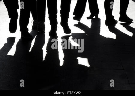Hoher Kontrast verschwommene Silhouetten und Schatten der Beine von Menschen zu Fuß Stockfoto