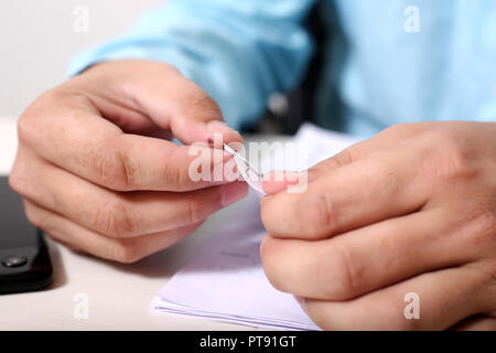 Der Mensch ist Anhängen mehrerer OME-Blatt mit Papier, Stift. Stockfoto