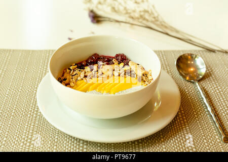 Gesundes Frühstück von Smoothie Schüssel mit Chia Pudding und Obst auf dem Tisch Stockfoto
