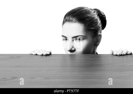 Frau lugen unter dem Rand der hölzernen Tisch. Stockfoto