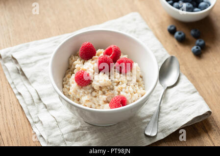 Haferflocken Haferbrei mit Früchten auf Leinen Textil. Gesundes Frühstück essen, Diät und gesunde Ernährung Konzept Stockfoto