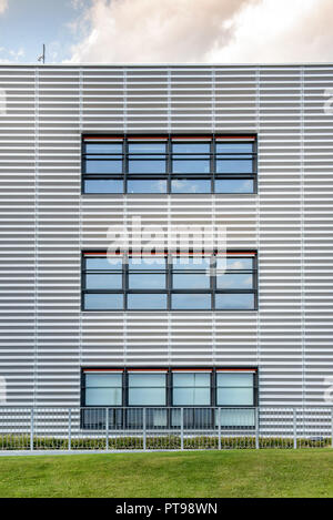 Symmetrische Ansicht eines modernen kommerziellen Gebäude mit drei großen breiten Fenstern und einem grünen Rasen vor Stockfoto