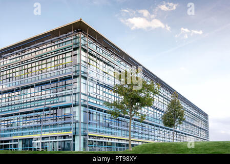Großes modernes Bürogebäude mit Bäumen im Vordergrund. Stockfoto