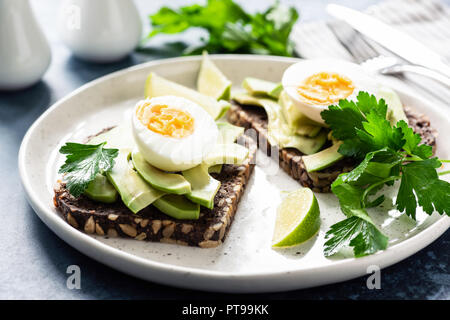 Toast mit Avocado und gekochtem Ei auf einem Teller, Detailansicht. Gesundes Frühstück, gesundes Essen oder Snack Konzept Stockfoto