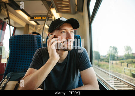 Eine Person oder eine touristische Fahrten mit dem Zug und Gespräche am Telefon. Stockfoto