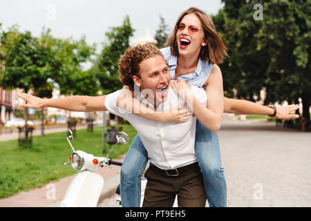 Bild von glückliches junges Paar, das Spaß zusammen mit Scooter, während er in Park Stockfoto