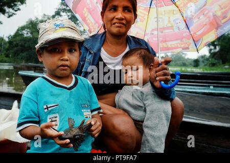 Mazedonien, Amazonien/Kolumbien - Mar 15 2016: Lokale Familie von einem Regenwald Jungle Village zurück von einer Angeltour mit niedlichen Kinder im Regen Stockfoto